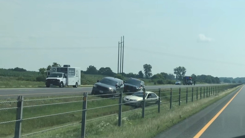 SIU and OPP vehicles are seen where a car rests in the ditch along Highway 401 in Chatham-Kent, Ont. on Wednesday, July 7, 2021. (Sean Irvine / CTV News)