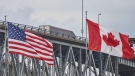 FILE - A truck crosses the Bluewater Bridge border crossing between Sarnia, Ont., and Port Huron, Michigan on Sunday August 16, 2020. THE CANADIAN PRESS/Geoff Robins