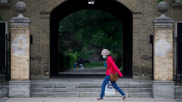 A person carrying a University of Toronto Book Store shopping bag walks on the University of Toronto campus in Toronto on September 8, 2020. THE CANADIAN PRESS/Cole Burston 