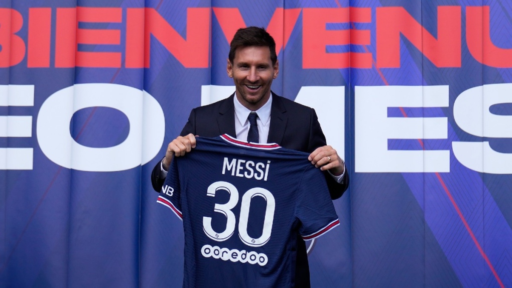 Lionel Messi holds his new PSG jersey