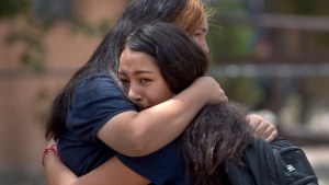 Students embrace after being released from school after a fatal shooting at Washington Middle School in Albuquerque, N.M., Aug. 13, 2021. (Robert Browman/The Albuquerque Journal via AP)