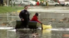 A woman tows a kayak in a flooded area of Duncan, B.C., on Nov. 20, 2009.