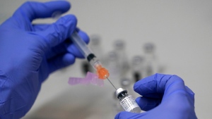 A pharmacy technician loads a syringe with Pfizer's COVID-19 vaccine, Tuesday, March 2, 2021, at a mass vaccination site at the Portland Expo in Portland, Maine. (AP Photo/Robert F. Bukaty)