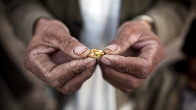 An Afghan man holds a small piece of gold, from the site of a proposed Qara Zaghan mine in 2011. (Benjamin Lowy / Getty Images via CNN)