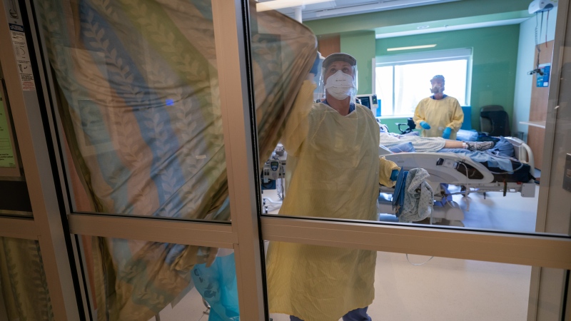 Nurses close the curtains of a patients room in the COVID-19 Intensive Care Unit at Surrey Memorial Hospital in Surrey, B.C., Friday, June 4, 2021. THE CANADIAN PRESS/Jonathan Hayward 