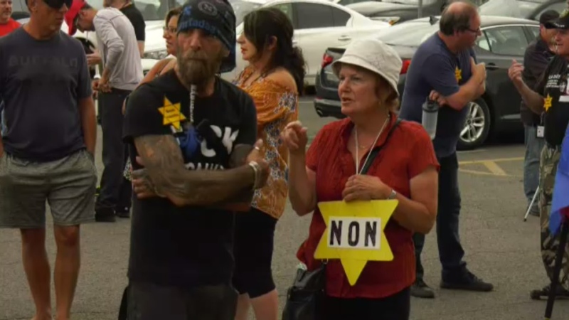 People wear yellow stars during a protest against Quebec's vaccine passport outside the Econofitness gym in Laval, Que. on Tuesday, Aug. 17, 2021. (CTV News)