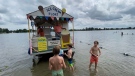 The Ice Cream Float lands ashore at Baxter Beach along the Rideau River as kids line up to cool off with a tasty treat. Ottawa, On. Aug. 18, 2021. (Tyler Fleming / CTV News)