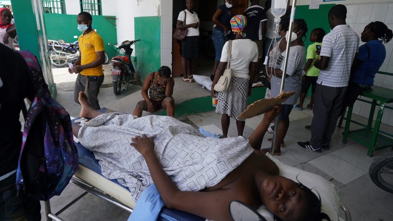 A person injured from the earthquake lies on a stretcher as another who was injured in a car accident sits behind, at the General Hospital in Les Cayes, Haiti, Wednesday, Aug. 18, 2021. (AP Photo/Fernando Llano) 