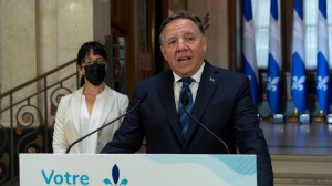 Quebec Premier Francois Legault gestures as he unveils his wish list to the leaders in the federal election, at his office in Quebec City, Thursday, Aug. 26, 2021. Quebec Treasury Board president Sonia Lebel, left, looks on. THE CANADIAN PRESS/Jacques Boissinot 
