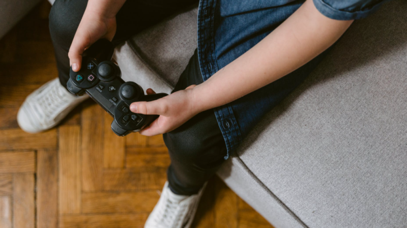 This stock image shows a child playing a video game. (Pexel)