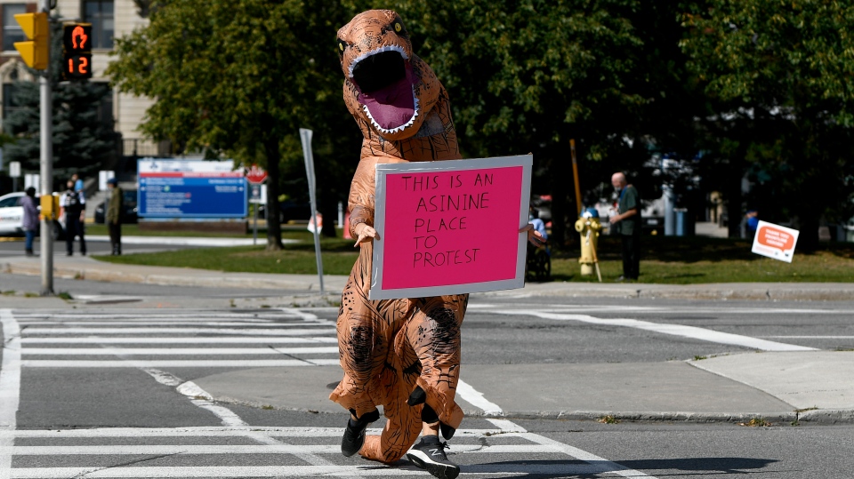 A counter-protester wearing a dinosaur suit