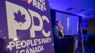 People's Party of Canada Leader Maxime Bernier and wife Catherine Letarte speaks from a podium to supporters during the PPC headquarters election night event in Saskatoon, Sask., Monday, Sept. 20, 2021. THE CANADIAN PRESS/Liam Richards