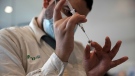 A medical worker prepares a vial of the Pfizer coronavirus vaccine at Clalit Health Service's centre in the Cinema City complex in Jerusalem, Wednesday, Sept. 22, 2021. (AP Photo/Maya Alleruzzo)