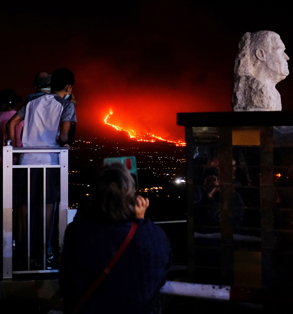 People watch the volcano spewing lava