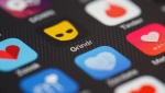 The Grindr app logo on a mobile phone, (Leon Neal/Getty Images/CNN)