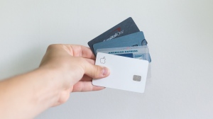 Stock image of person holding credit cards. (Unsplash, Avery Evans)
