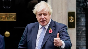 Britain's Prime Minister Boris Johnson meets with fundraisers for the Royal British Legion and purchases a poppy in front of 10 Downing in London, Friday, Oct. 29, 2021.(AP Photo/Alberto Pezzali)