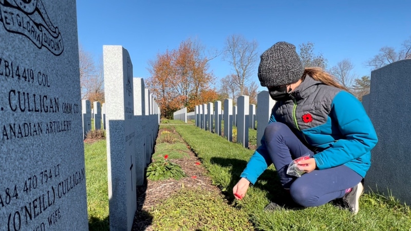 Grade 6 student Polly Almstedt lays a poppy at the grave of a fallen soldier at the National Military Cemetery. Ottawa, Ont. Nov. 1, 2021. (Tyler Fleming / CTV News Ottawa)
