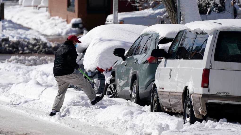 Clearing snow from a vehicle in Denver