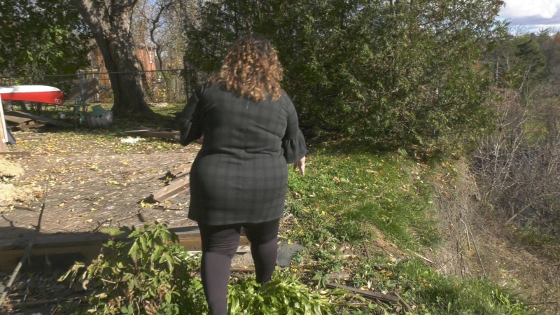 Leigh Costello shows how her backyard has been crumbling into the Muskrat River in Pembroke, Ont.  (Dylan Dyson/CTV News Ottawa)