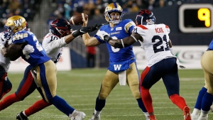 Winnipeg Blue Bombers quarterback Zach Collaros (8) gets pressure from Montreal Alouettes' Nick Usher (10) and Chris Ackie (21) during the first half of CFL action in Winnipeg Saturday, November 6, 2021. (THE CANADIAN PRESS/John Woods) 