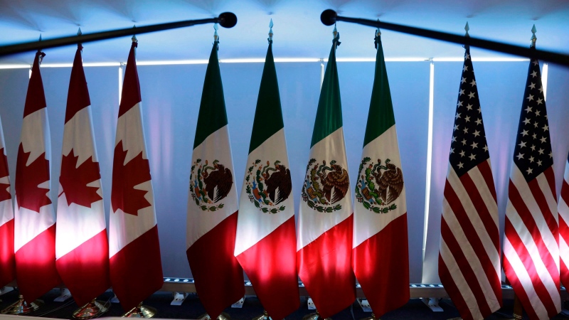 National flags representing Canada, Mexico, and the U.S. are lit by stage lights at the North American Free Trade Agreement, NAFTA, renegotiations, in Mexico City, on September 5, 2017. THE CANADIAN PRESS/AP, Marco Ugarte 