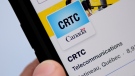 A person navigates to the on-line social-media pages of the Canadian Radio-television and Telecommunications Commission (CRTC) on a cell phone in Ottawa on Monday, May 17, 2021. THE CANADIAN PRESS/Sean Kilpatrick