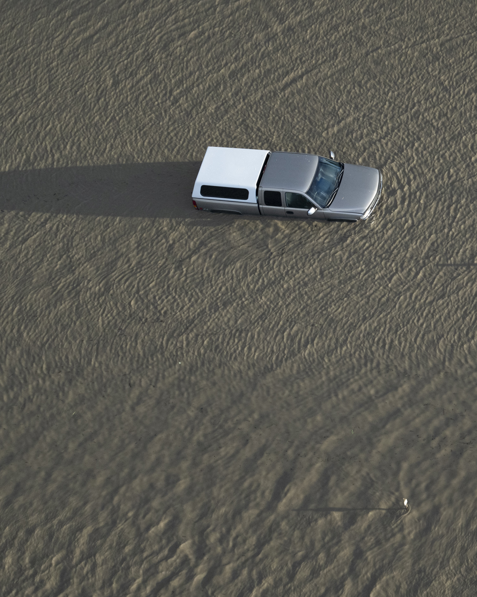 A stranded truck is surrounded by flood waters