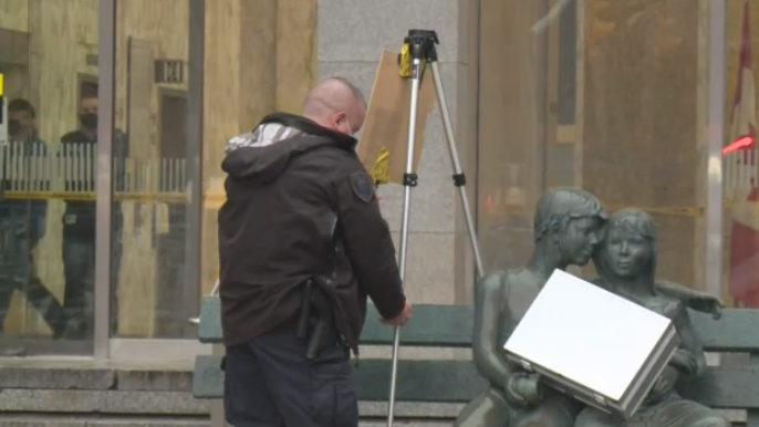 A briefcase in the arms of a statue outside Library and Archives Canada on Wellington Street Thursday morning.