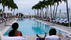 People lounge at a rooftop swimming pool at the 1 Hotel South Beach, Monday, Nov. 15, 2021, in Miami Beach, Fla. (AP Photo/Lynne Sladky) 
