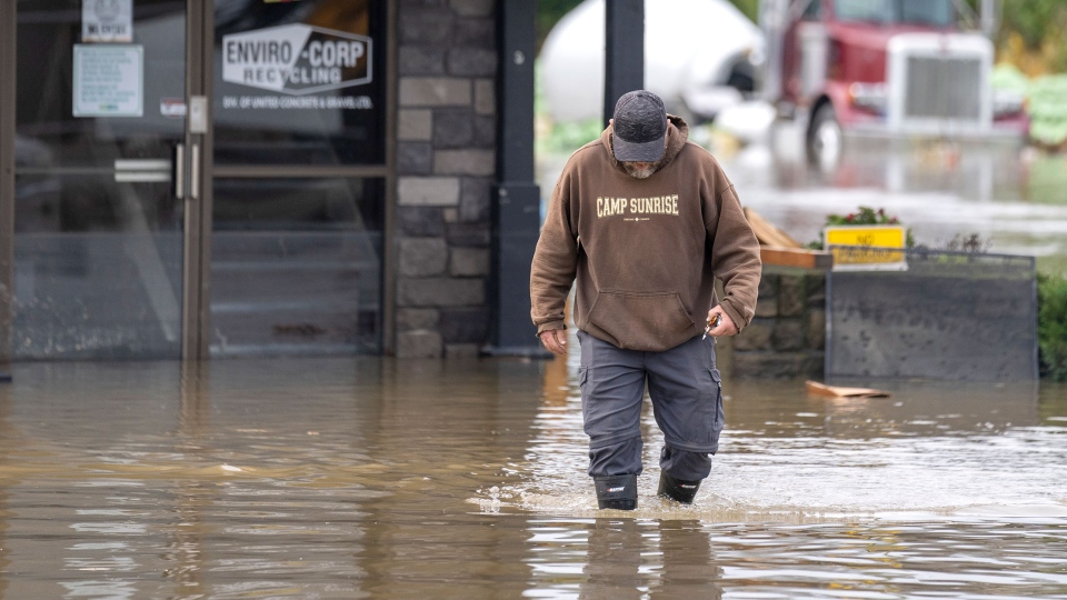 A man walks through rising flood waters in B.C.