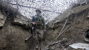 Ukrainian soldiers walks under a camouflage net in a trench on the line of separation from pro-Russian rebels near Debaltsevo, Donetsk region, Ukraine, Ukraine Friday, Dec 3, 2021. (AP Photo/Andriy Dubchak) 
