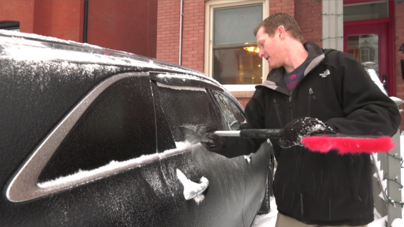 A man chips ice away from his car windows following freezing rainfall in Ottawa. Dec. 6, 2021. (Leah Larocque/CTV News Ottawa)
