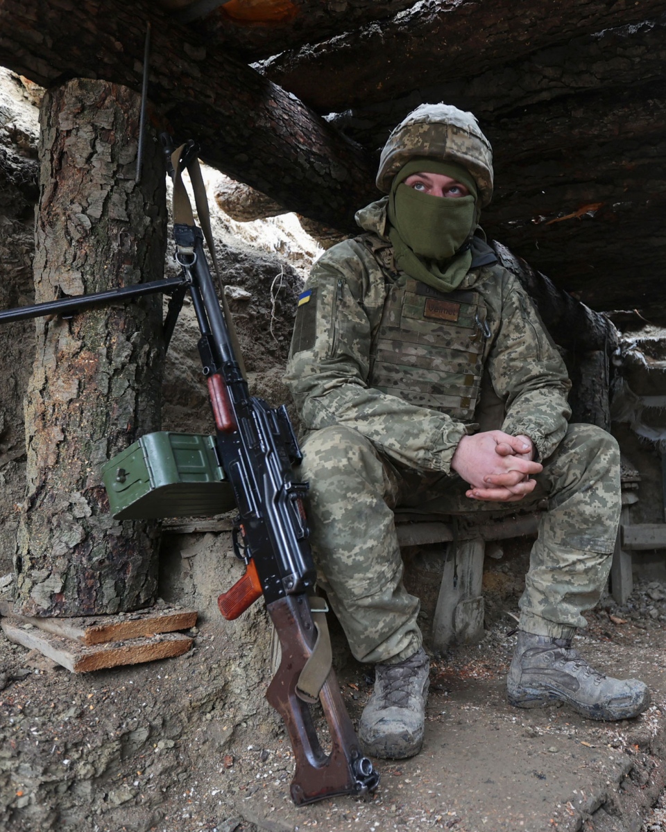 Seorang tentara Ukraina duduk dalam posisi bertarung