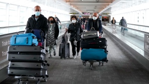 People travel at Pearson International Airport during the COVID-19 pandemic in Toronto, Friday, Dec. 3, 2021. New travel testing and restrictions have been put in place due to the newly discovered B.1.1.529 coronavirus variant, now known as Omicron. THE CANADIAN PRESS/Nathan Denette