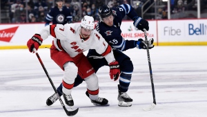 Winnipeg Jets' Mark Scheifele (55) and Carolina Hurricanes’ Brendan Smith (7) skate after the loose puck during the second period of NHL action in Winnipeg on Tuesday December 7, 2021. THE CANADIAN PRESS/Fred Greenslade 