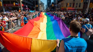 Volunteers with Pride Toronto carry a large rainbow flag during the 2019 Pride Parade in Toronto, Sunday, June 23, 2019. THE CANADIAN PRESS/Andrew Lahodynskyj 