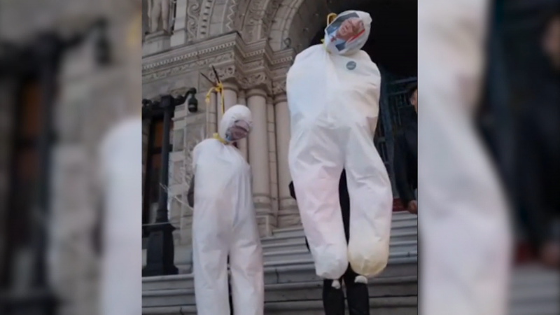 Effigies of Premier John Horgan and Health Minister Adrian Dix are seen at a protest outside the B.C. legislature on Dec. 9, 2021. 