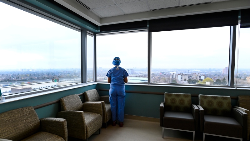 Registered nurse Stephanie Flores, who has been redeployed from the operating room to the intensive care unit, looks out the window in the ICU at the Humber River Hospital during the COVID-19 pandemic in Toronto on Tuesday, April 13, 2021. THE CANADIAN PRESS/Nathan Denette 