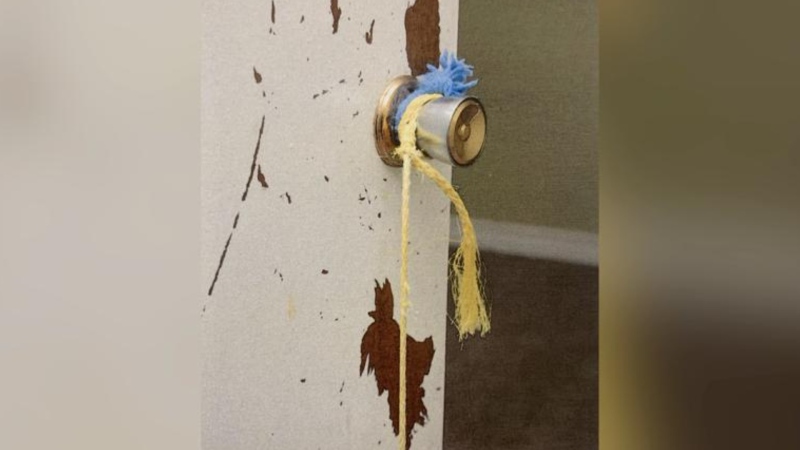 Yellow rope wrapped around the boys’ bedroom doorknob and tied to a banister to keep the children confined. (Saskatoon Provincial Court)