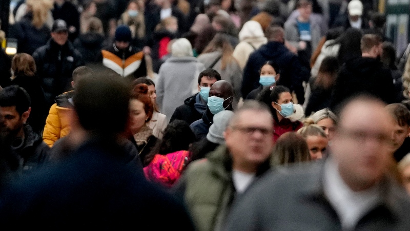 Shoppers walk along Oxford Street, Europe's busiest shopping street, in London, Saturday, Dec. 18, 2021. Soaring infections in Britain driven in part by the omicron variant of the coronavirus are rattling Europe. . (AP Photo/Frank Augstein) 