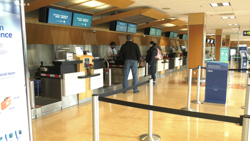 Passengers check in at the WestJet counter at Victoria International Airport on Dec. 23, 2021. (CTV News)