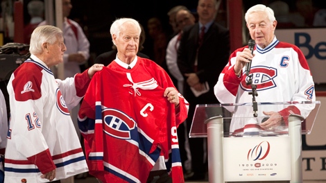Former Detroit Red Wings Gordie Howe holds former Montreal Canadiens' Jean Beliveau jersey as Dickie Moore, left, looks on during centennial celebrations Friday, December 4, 2009 in Montreal. (Paul Chiasson / THE CANADIAN PRESS)