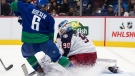 Columbus Blue Jackets goalie Elvis Merzlikins (90), of Latvia, stops Vancouver Canucks' Brock Boeser (6) during the second period of an NHL hockey game in Vancouver, on Tuesday, Dec. 14, 2021. (Darryl Dyck / THE CANADIAN PRESS)