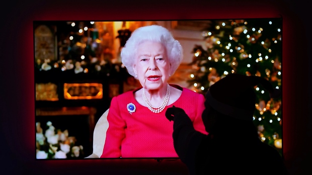 A child is silhouetted on a television screen in Larbert, England, on Dec. 25, 2021, as she watches Queen Elizabeth II give her annual Christmas broadcast from Windsor Castle. (Andrew Milligan/PA via AP)