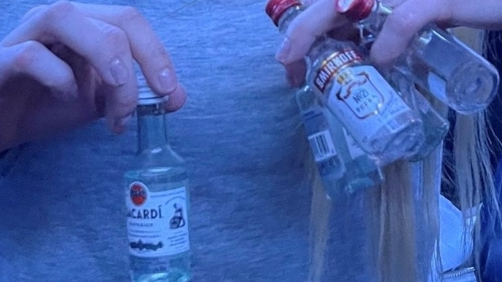 A woman shows off mini-bottles of liquor about a Sunwing flight where Quebec influencers were partying.