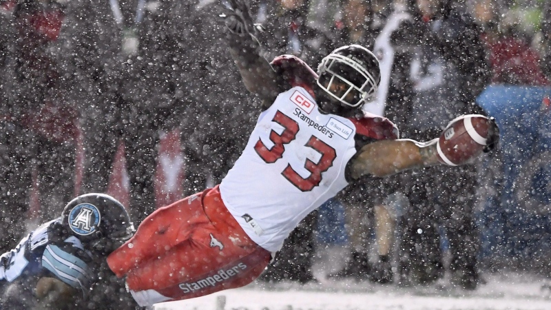 Calgary Stampeders running back Jerome Messam (33) is tackled by Toronto Argonauts linebacker Terrance Plummer (47) as he scores a touchdown during first half CFL football action in the 105th Grey Cup in 2017 in Ottawa. (THE CANADIAN PRESS/Sean Kilpatrick)