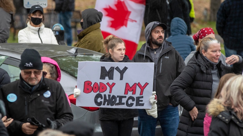 People gather to protest COVID-19 vaccine mandates and masking measures during a rally in Kingston, Ont., on Sunday Nov. 14, 2021. THE CANADIAN PRESS/Lars Hagberg 