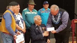 Louis Roy is seen receiving recognition and a cheque from the Manitoba Metis Federation in a 2019 handout photo. Roy was the first Metis veteran to receive a recognition payment from Ottawa after Prime Minister Justin Trudeau apologized for how they were treated upon return from the war. (THE CANADIAN PRESS/HO-Glenda Burnouf.)
