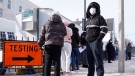 People wear face masks, to protect from the spread of the COVID-19 virus, as they wait in line to be tested for the virus outside the Bowdoin Street Health Center, Wednesday, Jan. 12, 2022, in Boston. (AP Photo/Charles Krupa)